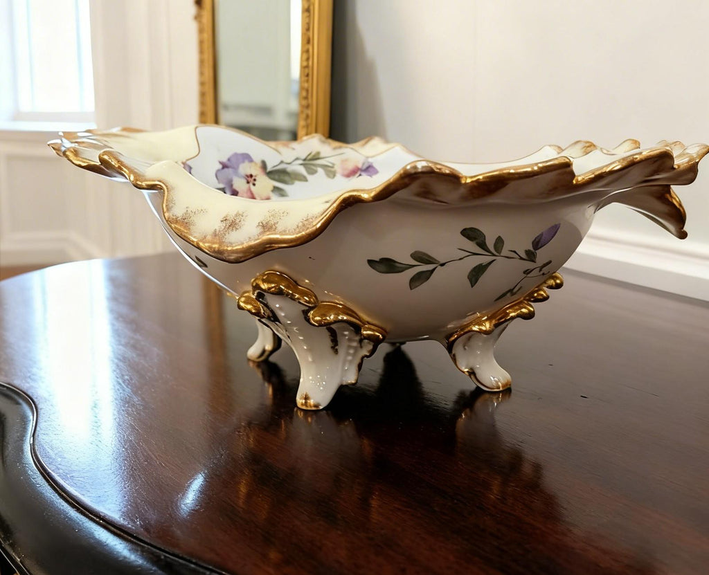 https://chairish-prod.freetls.fastly.net/image/product/master/a64d9dad-8514-4cd1-9063-5c6f2bf7987c/vintage-hand-painted-hollywood-regency-porcelain-centerpiece-bowl-with-gilt-trim-and-floral-motif-3353